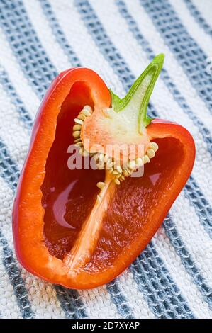 Un peperone rosso dolce tagliato in due parti e. mostrare i semi e l'interno Foto Stock