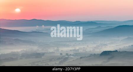 Toscana paesaggio collinare in scena con la mattina presto haze sulla campagna di villaggio Foto Stock