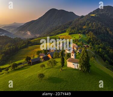 Sveti Andrej, Slovenia - veduta aerea del drone della chiesa di Sant'Andrea (Sv. Andrej) al tramonto nella zona di Skofja Loka. Estate nelle alpi slovene Foto Stock