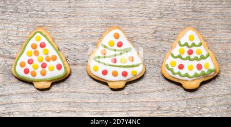 Biscotti di Natale sotto forma di alberi su sfondo di legno. Foto Stock