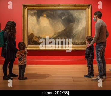 Londra 26 ottobre 2020 una famiglia che guarda la tempesta della neve: Hannibal e la sua Armata che attraversa le Alpi 1812 olio su tela Tate Britain la nuova mostra dedicata a JMW Turner Modern's World Exploring Turner's Modern World rivela come il più grande pittore paesaggistico della Gran Bretagna abbia trovato nuovi modi per catturare gli eventi più importanti della sua epoca, dall'impatto della tecnologia sul mondo naturale agli effetti vertiginosi della modernizzazione sulla società. Turner's Modern World si terrà dal 28 ottobre 2020 al 7 marzo 2021. Paul Quezada-Neiman/Alamy Live News Foto Stock