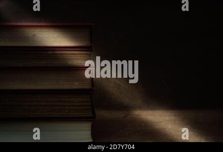 vecchi libri accatastati su tavolo, moody con spazio per il testo, concetto di passsing del tempo . Foto Stock