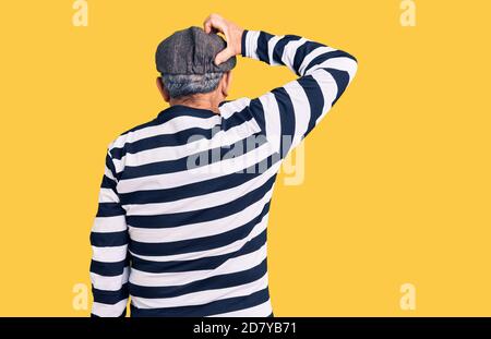 Uomo anziano bello indossando maschera di scasso e t-shirt pensiero all'indietro circa il dubbio con la mano sulla testa Foto Stock