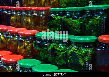 Banche con diversi tipi di miele nel mercato. Miele con abete e foglie di tiglio in lattine. Foto Stock