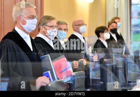 26 ottobre 2020, Turingia, Weimar: I giudici della Corte costituzionale Turingia si trovano fianco a fianco nella sala di giustizia all'inizio del procedimento, con bocche e naso coperti. La Corte costituzionale dello Stato sta sentendo una denuncia dell'AFD della Turingia contro la commissione delle difficoltà dello Stato. Secondo il ministero delle migrazioni, la commissione può concedere permessi di soggiorno ai rifugiati e ad altri stranieri che dovrebbero lasciare il paese secondo una decisione delle autorità. Le decisioni hanno avuto un ruolo da parte di ragioni umanitarie o personali. Una decisione è attesa in De Foto Stock