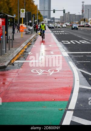 Berlino, Germania. 26 Ottobre 2020. Il ridisegnato Karl-Marx-Allee con ampie piste ciclabili, migliori possibilità di attraversamento per i pedoni e una prenotazione centrale presto da ingrossare è stato completato ed è stato consegnato oggi dopo un periodo di costruzione di 28 mesi. La ricostruzione della strada principale tra Strausberger Platz e otto-Braun-Straße è stata effettuata a favore del traffico pedonale e ciclistico. Invece di parcheggi, c'è un'area verde nel mezzo di Karl-Marx-Allee, per esempio. Credit: Jens Kalaene/dpa-Zentralbild/ZB/dpa/Alamy Live News Foto Stock