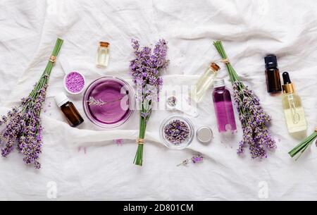 Set di oli di lavanda siero e lavanda fiori. Prodotti cosmetici Skincare. Prodotti naturali di bellezza spa. Olio essenziale di lavanda, siero, burro corporeo Foto Stock