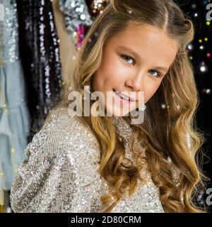 Giovane bella ragazza adolescente elegante in abito elegante festa in sequins giocosamente felice sorridente. Ritratto dello studio. Natale e Capodanno Foto Stock