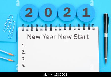 2021 New Year New Start scritto su un diario sfondo blu Foto Stock