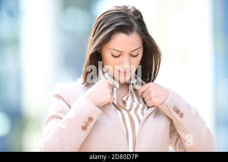 Bella imprenditore che controlla la camicia in piedi per strada Foto Stock