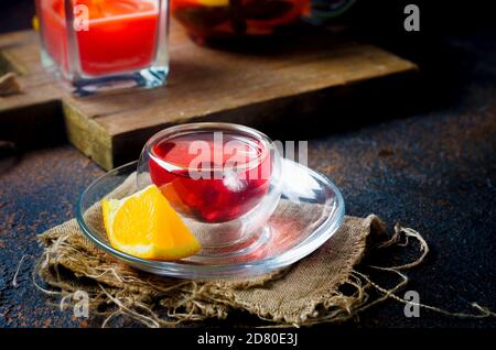 Tè rosso alla frutta aromatizzato in una tazza di vetro e bollitore, cerimonia del tè Foto Stock