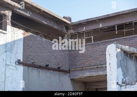 Vecchia fabbrica di fertilizzanti abbandonata mattoni e pietra edificio facciata rovine a Drapetsona Pireo Grecia, cielo blu, giorno di sole. Impianto industriale storico, t Foto Stock