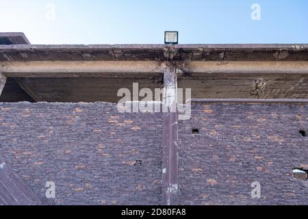 Vecchia fabbrica di fertilizzanti abbandonata mattoni e pietra edificio facciata rovine a Drapetsona Pireo Grecia, cielo blu, giorno di sole. Impianto industriale storico, t Foto Stock