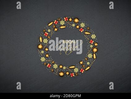 Piatto Lay ornamenti dorati di natale disposti come un cerchio su una piastra di pietra nera. Testo italiano 'buon Natale' (buon Natale) nel mezzo. Foto Stock