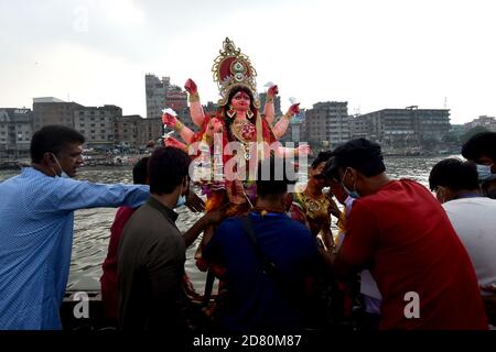 Dhaka. 26 Ottobre 2020. I devoti indù si preparano ad immergere un idolo della Dea Durga in un fiume durante il festival Durga Puja a Dhaka, Bangladesh, 26 ottobre 2020. Credit: Xinhua/Alamy Live News Foto Stock