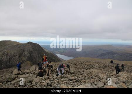 La gente sulla sommt del luccio di scafell nel lago Distretto in autunno Foto Stock