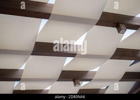 soffitto estivo con travi in legno e tessuto bianco e bianco cielo Foto Stock