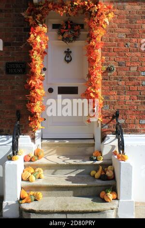 RYE, EAST SUSSEX, UK - 10/29/2020: Decorazione della zucca di Halloween sulla porta e stoop con midollo di zucca d'autunno e verdure di squash Foto Stock