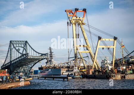 Wilhelmshaven, Germania. 26 Ottobre 2020. Una gru galleggiante trasporta il ponte della diga attraverso il ponte Kaiser-Wilhelm. Il ponte sospeso più di 100 anni fa viene trasportato ad Hannoverkai per la riparazione. Credit: Sina Schuldt/dpa/Alamy Live News Foto Stock