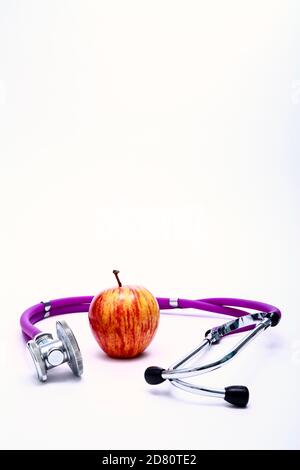 Immagine concettuale di un'alimentazione sana di una mela e di medici stetoscopio con spazio di copia Foto Stock