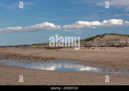 Bellissimi riflessi del cielo lungo una spiaggia con dune di sabbia in background-4 Foto Stock