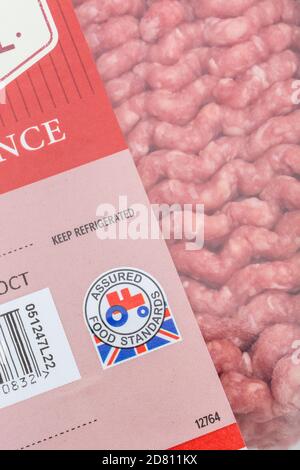 Pellicola di plastica rivestita di carne tritata di Tesco / macinata di manzo con il logo del trattore rosso standard Food Assured. Prodotti agricoli britannici, Union Jack su involucri alimentari Foto Stock