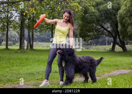 La donna allena la brigata in un parco. Foto Stock