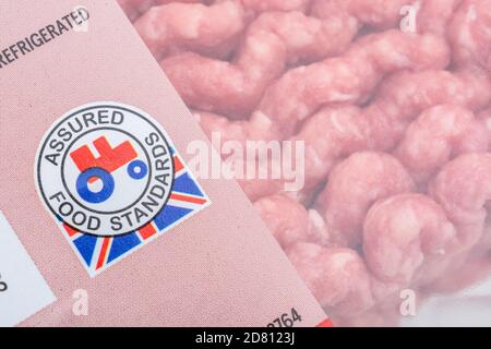 Pellicola di plastica rivestita di carne tritata di Tesco / macinata di manzo con il logo del trattore rosso standard Food Assured. Prodotti agricoli britannici, Union Jack su involucri alimentari Foto Stock