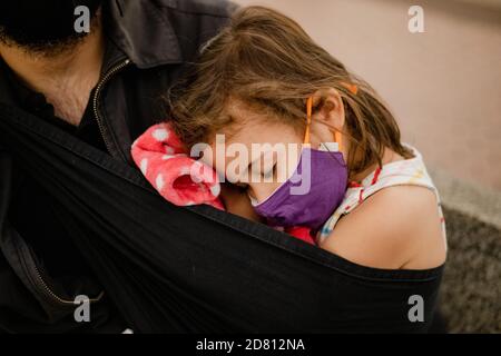 bambina che dorme con la maschera facciale sul suo papà Foto Stock