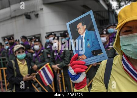 Bangkok, Thailandia. 26 Ottobre 2020. Un protetore pro-monarchico tiene il ritratto del re Bhumibol Adulyadej (Rama 9) durante una manifestazione fuori dell'ambasciata della Germania. I manifestanti di camicie gialle si sono riuniti fuori dell'ambasciata tedesca a Sathorn Road, per dimostrare il loro sostegno alla monarchia, hanno anche inviato una lettera che spiega la situazione politica in Thailandia per l'ambasciatore Georg Schmidt, firmato da Nitiretorn Lamlua e Pichit Chaimongkol del movimento "Popolo della Thailandia". Credit: SOPA Images Limited/Alamy Live News Foto Stock