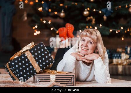 Donna elegante sorridente di 50 anni, donna matura con nastro regalo a  sorpresa, regalo di natale in mano, rossetto rosso e festa della sera Foto  stock - Alamy