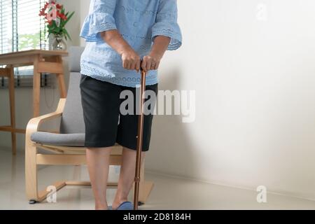 Dolore al ginocchio della donna anziana con bastone, problema sanitario di concetto senior Foto Stock