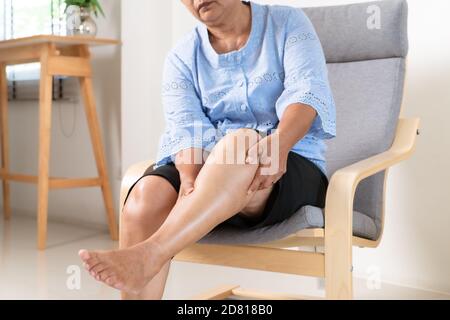 Senior donna che soffrono di dolore al ginocchio a casa, il problema della salute concetto Foto Stock