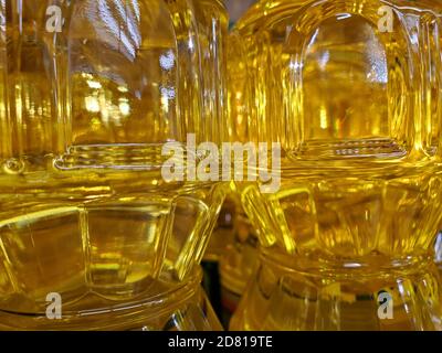 Tonalità d'oro sfondo astratto di olio vegetale giallo all'interno astratto forme geometriche di bottiglie lucide trasparenti primo piano Foto Stock