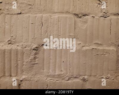 Superficie irregolare di vecchio muro di mattoni spaccati closeup. Giunti cementizi ruvidi e tessuti nervati di muratura in muratura Foto Stock