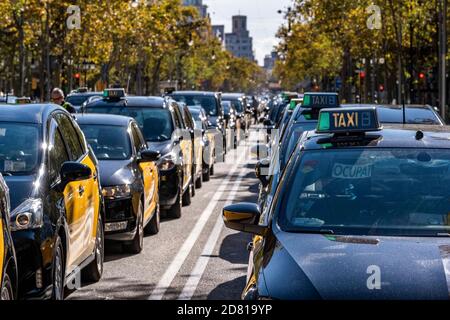 Un gran numero di taxi veicoli sono visti parcheggiati in una fila sul Passeig de Gràcia a Barcellona. Le principali organizzazioni di tassisti e sindacati a Barcellona hanno indetto una giornata di sciopero parcheggiando i loro veicoli nel centro della città e chiamando un'assemblea di fronte al Delegazione del governo spagnolo in Catalogna. Il settore dei taxi richiede aiuto per far fronte al basso reddito economico dovuto alla pandemia Covid19 che mantiene la maggior parte di tutti i commerci e il tempo libero senza attività. Foto Stock