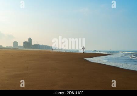 Silhouette di un uomo che ha una passeggiata lungo la spiaggia del Mare del Nord di Ostenda (Ostenda), Belgio. Foto Stock