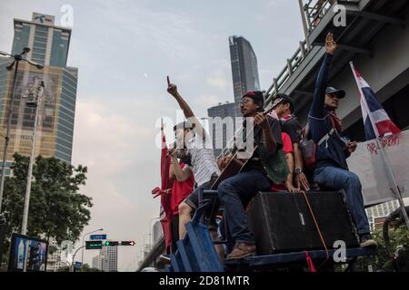 Bangkok, Thailandia. 26 Ottobre 2020. Un sostenitore pro-democrazia ha tenuto un discorso con una grande immagine del re tailandese Maha Vajiralongkorn (Rama X) sullo sfondo durante una manifestazione anti-governo nella capitale tailandese. Migliaia di manifestanti favorevoli alla democrazia hanno marciato dall'intersezione di Samyan all'ambasciata di Germania per consegnare una lettera per chiedere un'indagine sulla residenza del re tailandese (Rama X) Maha Vajiralongkorn in Germania, nonché per chiedere le dimissioni del primo ministro tailandese e la riforma della monarchia. Credit: SOPA Images Limited/Alamy Live News Foto Stock