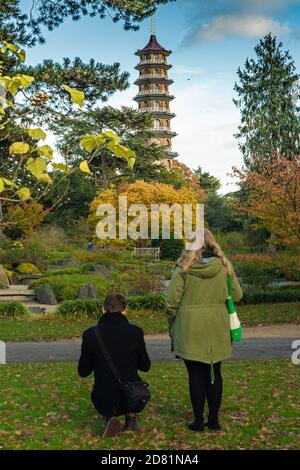 Londra, Regno Unito. Lunedì 26 ottobre 2020. Due visitatori scattano foto della pagoda nei Kew Gardens di Londra. I giardini si stanno rivelando una giornata popolare per le famiglie durante il semestre autunnale, in quanto altre opzioni sono limitate dalle restrizioni pandemiche. Foto: Roger Garfield/Alamy Live News Foto Stock