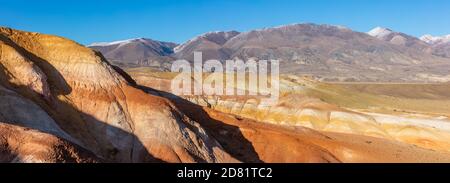 Scatto panoramico di massicce montagne rosse nella valle di Kyzyl-Chin, chiamata anche valle di Marte. Cielo blu come sfondo. Altai, Siberia, Russia. Foto Stock
