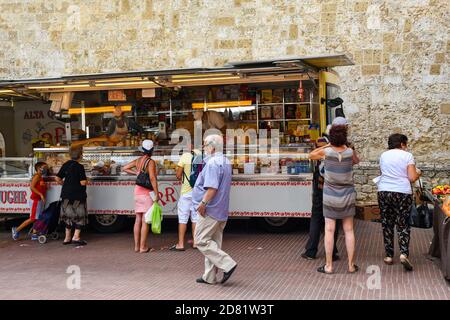 La gente acquista in un camion del mercato alimentare nel centro storico di San Gimignano, Patrimonio dell'Umanità dell'UNESCO, Siena, Toscana, Italia Foto Stock