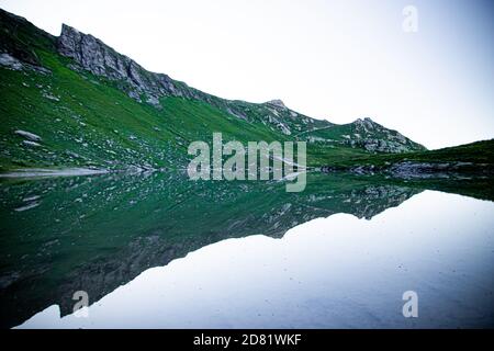 Fantastiche vedute del tranquillo lago con un incredibile riflesso. Montagne sullo sfondo. Tranquillo paesaggio pittoresco. Svizzera Foto Stock