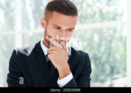 Ritratto di un uomo d'affari in un moderno ufficio creativo con spazio per la copia. Concetto di dubbio, soluzione, decisione ed emozioni Foto Stock
