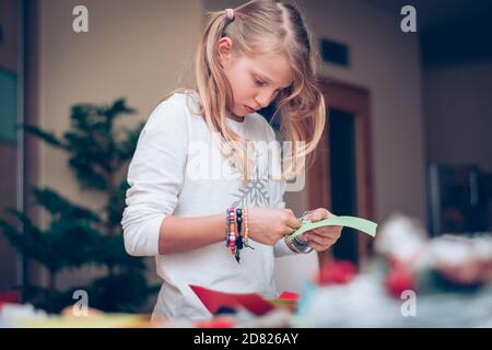 adorabile ragazza bionda che fa il biglietto di natale per amici e parenti Foto Stock