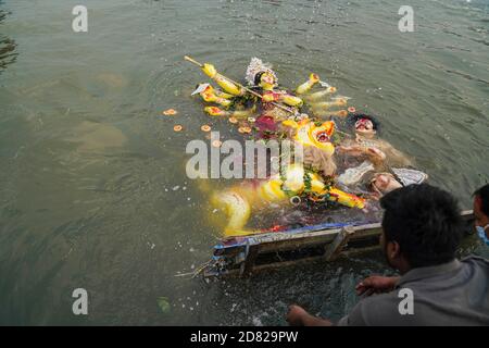 I devoti indù immergono l'idolo della dea indù Durga nel fiume Buriganga durante l'ultimo giorno del festival Durga Puja. Il Durga Festival di quattro giorni si celebra in tutto il Bangladesh e culmina nell'immersione degli idoli della dea indù Durga per simboleggiare il potere e il trionfo Bene sopra il male nella mitologia indù. Foto Stock