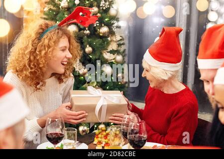 Donna felice che dà la scatola presente alla sua nonna Foto Stock