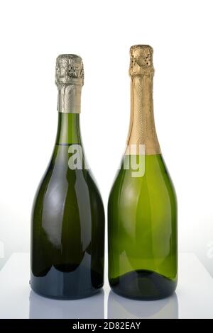Due bottiglie di champagne senza etichette su sfondo chiaro. Foto Stock