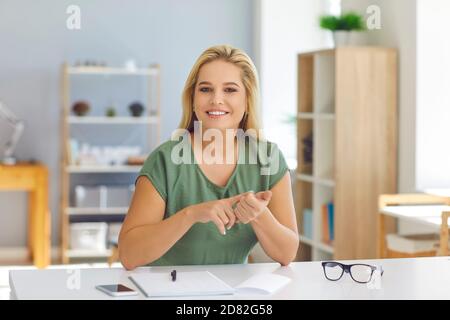 Insegnante sorridente o allenatore di vita che parla con studenti o clienti durante la videochiamata online Foto Stock