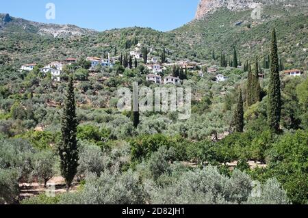 Villaggio di montagna nel tipico paesaggio con cipressi e ulivi della Grecia Foto Stock