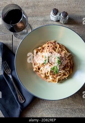 Pasta bolognese servita in ristorante italiano con vino rosso Foto Stock